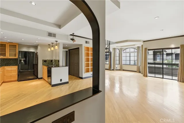 a view of a kitchen with stainless steel appliances wooden floor and a large window