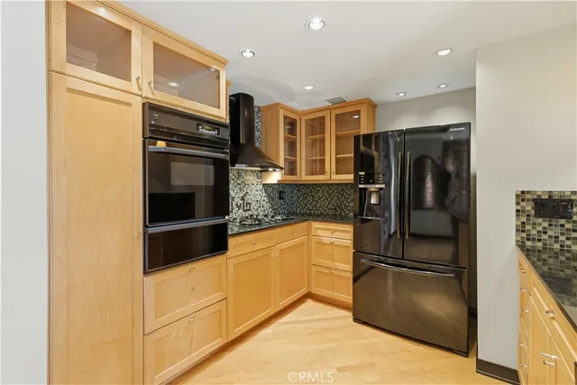 a kitchen with stainless steel appliances granite countertop a refrigerator and a stove