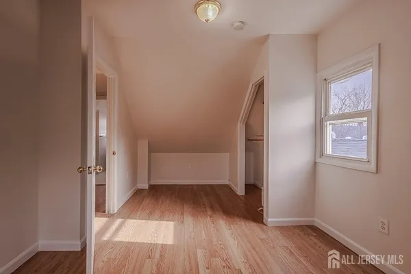 an empty room with wooden floor and a window