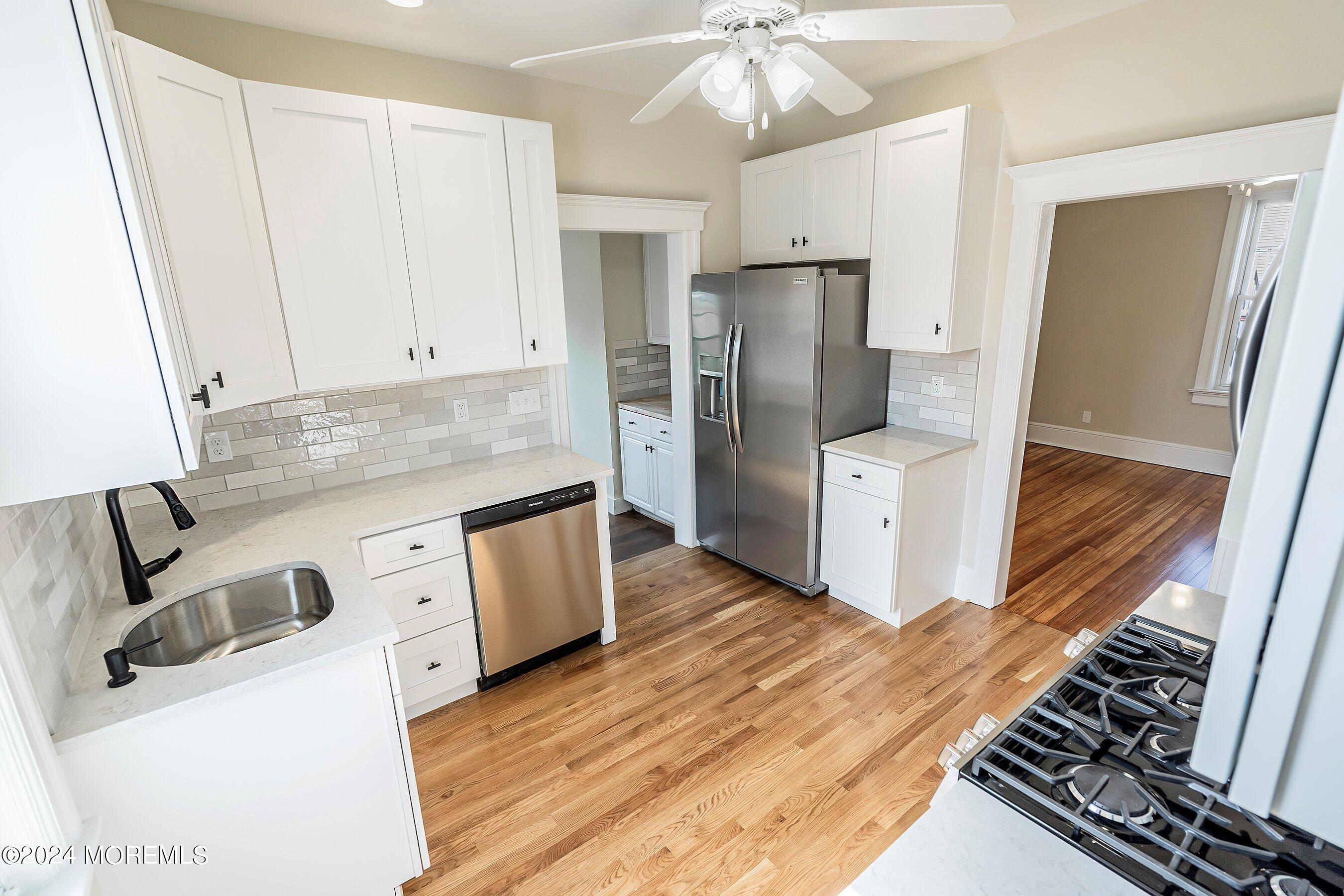 1202 River Road Belmar, NJ 07719 - Photo 13 of 32 a kitchen with stainless steel appliances granite countertop a refrigerator a stove and a wooden floors