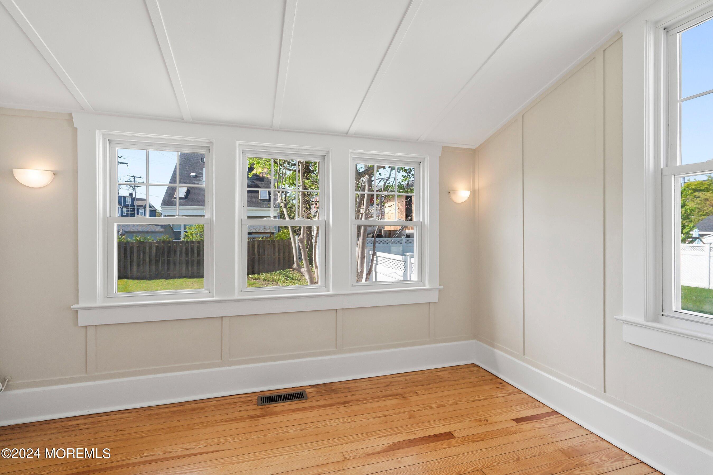 1202 River Road Belmar, NJ 07719 - Photo 18 of 32 a view of an empty room with wooden floor and a window