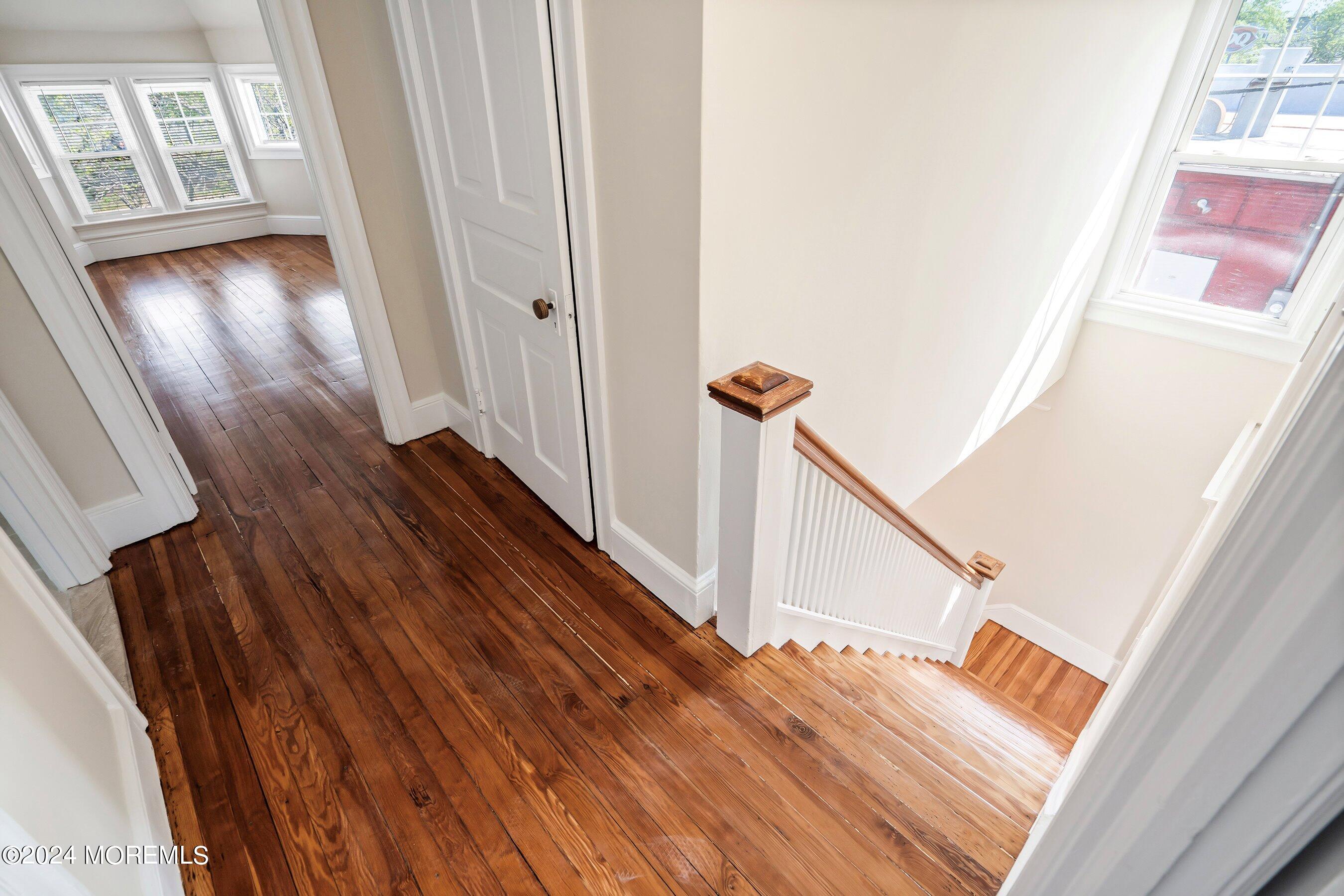 1202 River Road Belmar, NJ 07719 - Photo 20 of 32 a view of a hallway with wooden floor and staircase