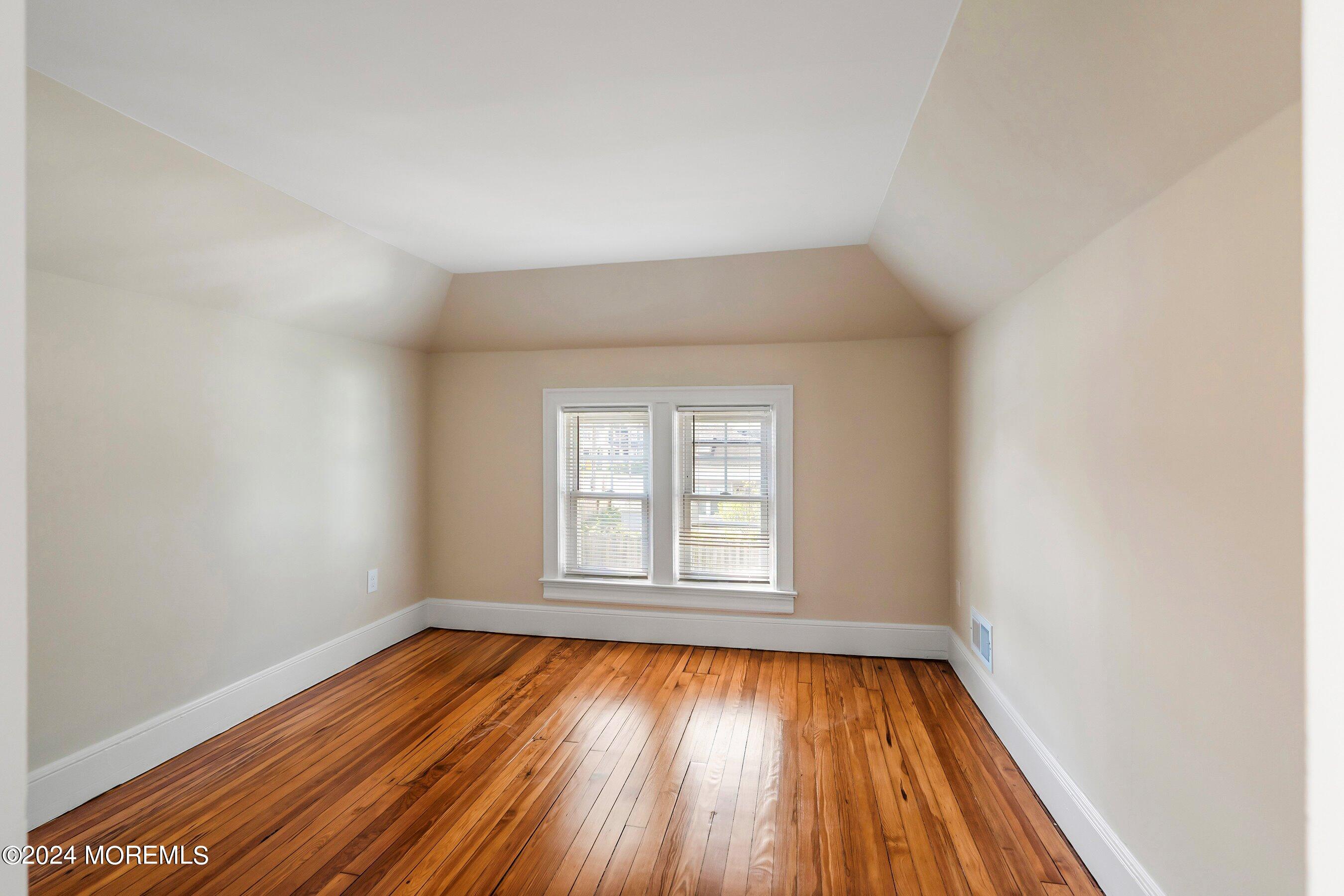 1202 River Road Belmar, NJ 07719 - Photo 24 of 32 an empty room with wooden floor and windows