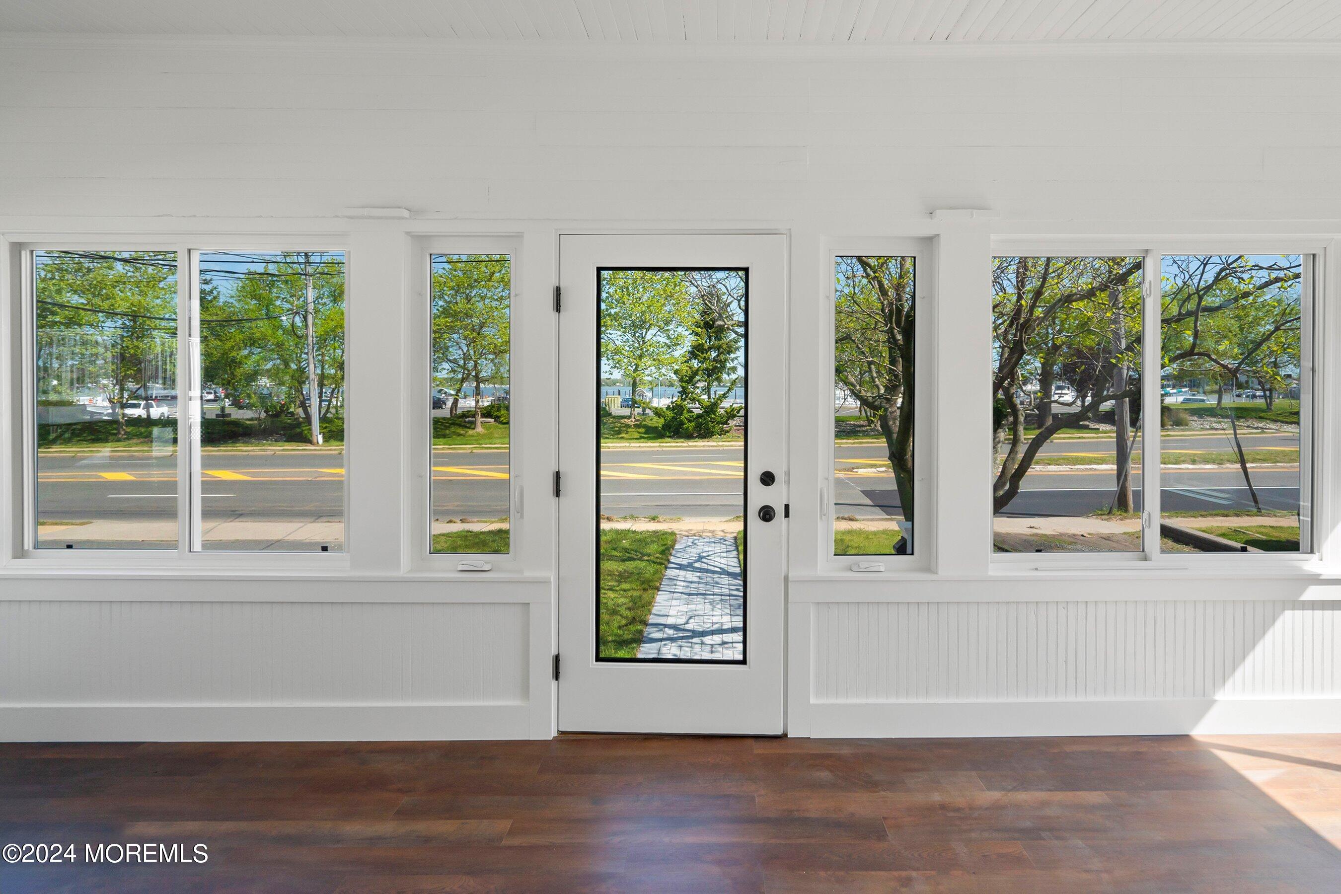 1202 River Road Belmar, NJ 07719 - Photo 5 of 32 a view of an empty room with wooden floor and a window
