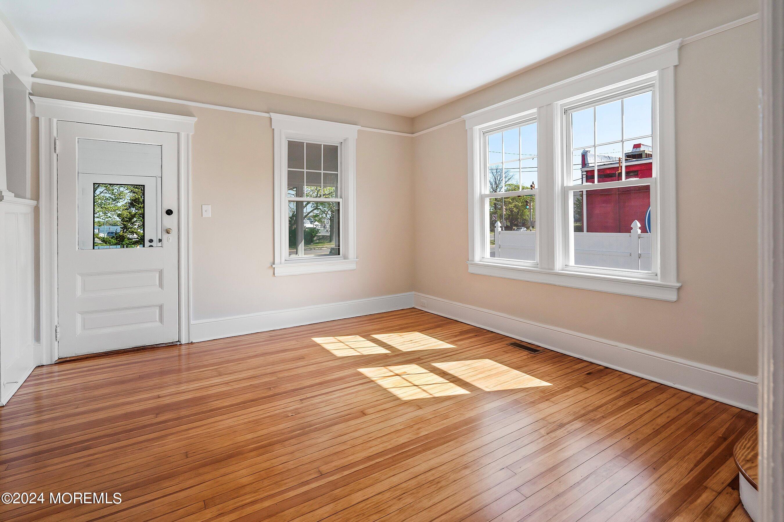 1202 River Road Belmar, NJ 07719 - Photo 9 of 32 a view of an empty room with wooden floor and a window