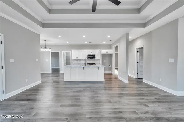a large kitchen with kitchen island white cabinets and stainless steel appliances