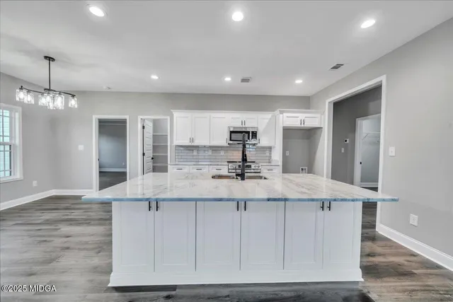 a kitchen with stainless steel appliances granite countertop a stove a microwave and sink