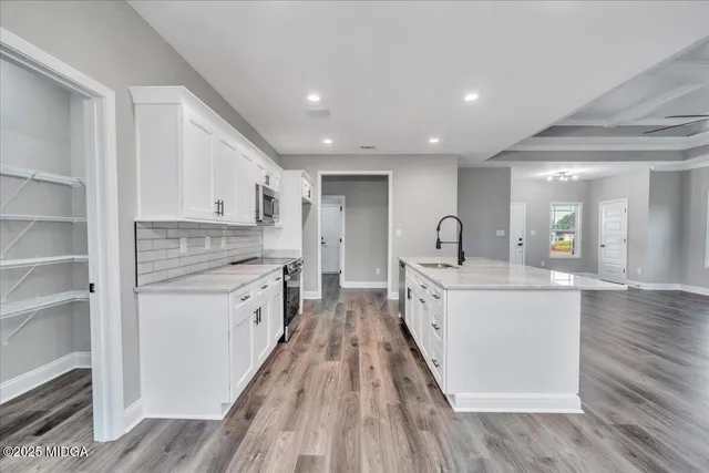 a spacious bathroom with a granite countertop sink a mirror and a shower