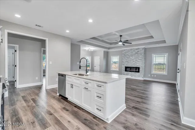 a large white kitchen with lots of counter space wooden floor and appliances