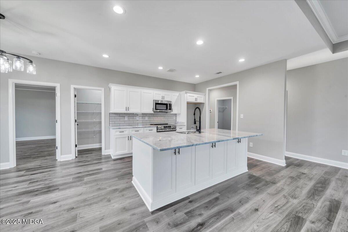 200 Eric Court Byron, GA 31008 - Photo 24 of 58 a large white kitchen with kitchen island a sink wooden floor and a refrigerator