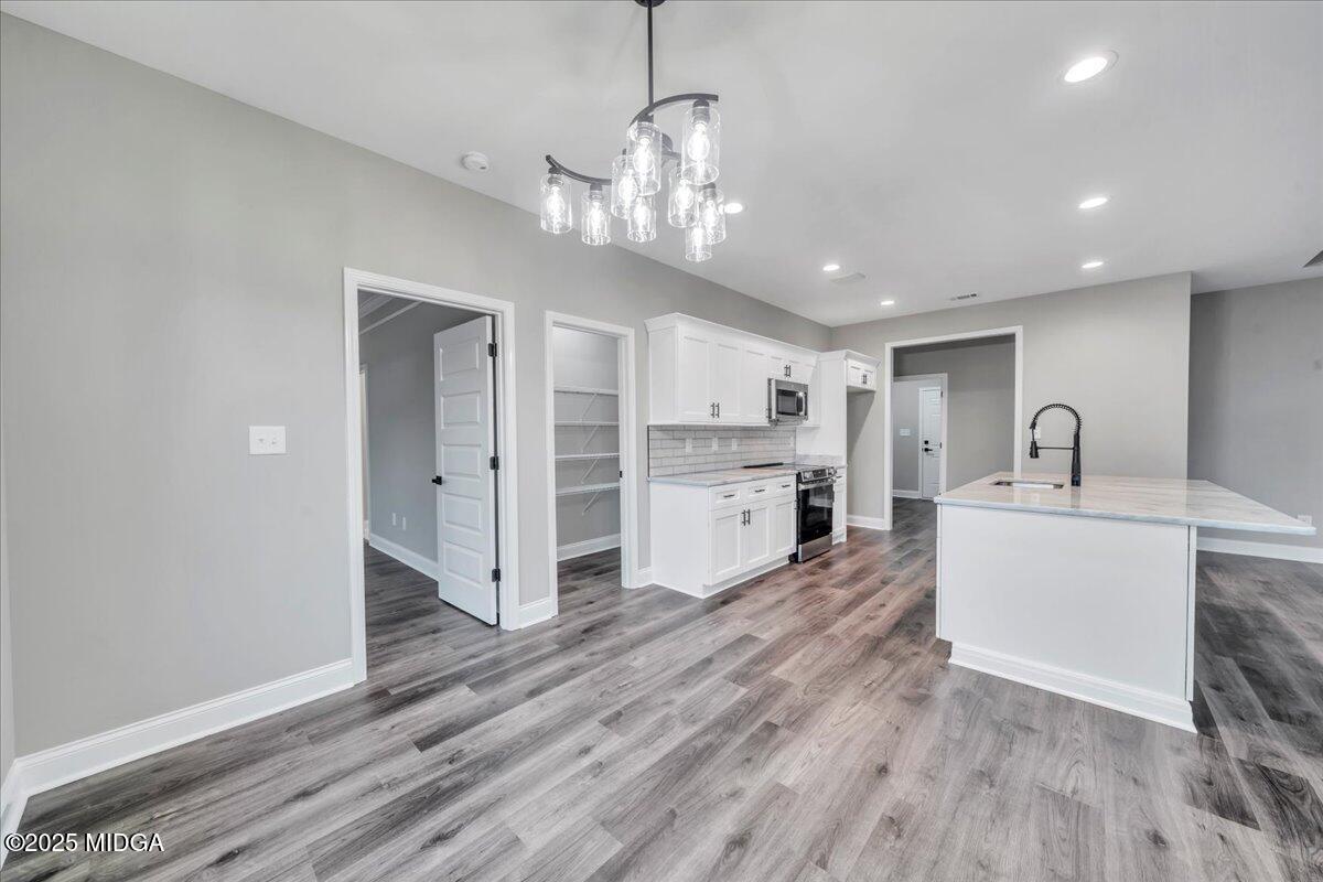 200 Eric Court Byron, GA 31008 - Photo 27 of 58 a large white kitchen with lots of counter space wooden floor and appliances