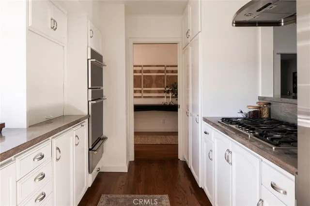 a kitchen with white cabinets and appliances