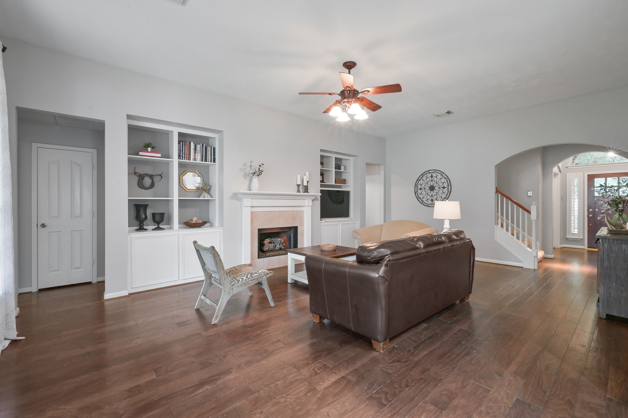 2 Westward Ridge Place The Woodlands, TX 77384 - Photo 21 of 43 The inviting living room features a fireplace flanked by elegant bookcases and cabinets, offering both warmth and plenty of storage