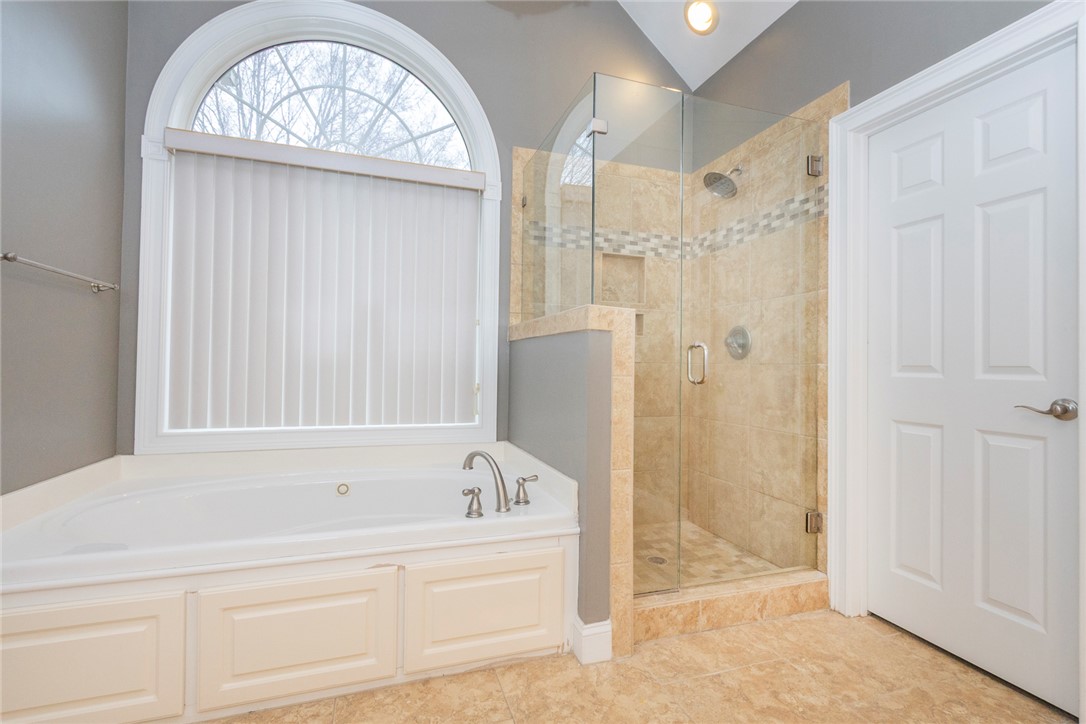 105 Sycamore Drive Clemson, SC 29631 - Photo 24 of 35 This serene bathroom offers a soaking tub, a spacious glass-enclosed shower, and elegant tile flooring.