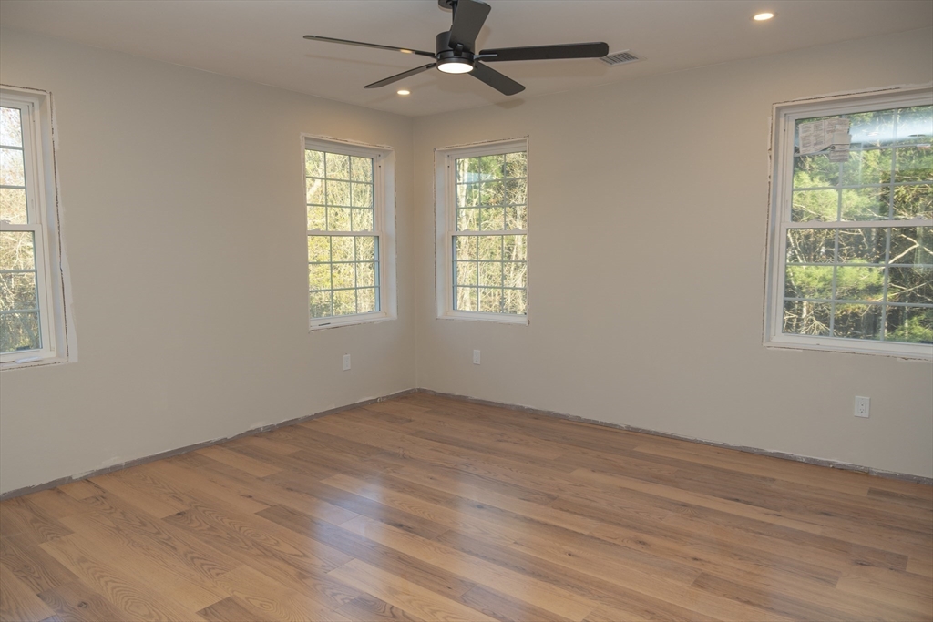 28 Marion Road Rochester, MA 02770 - Photo 16 of 23 an empty room with wooden floor fan and windows
