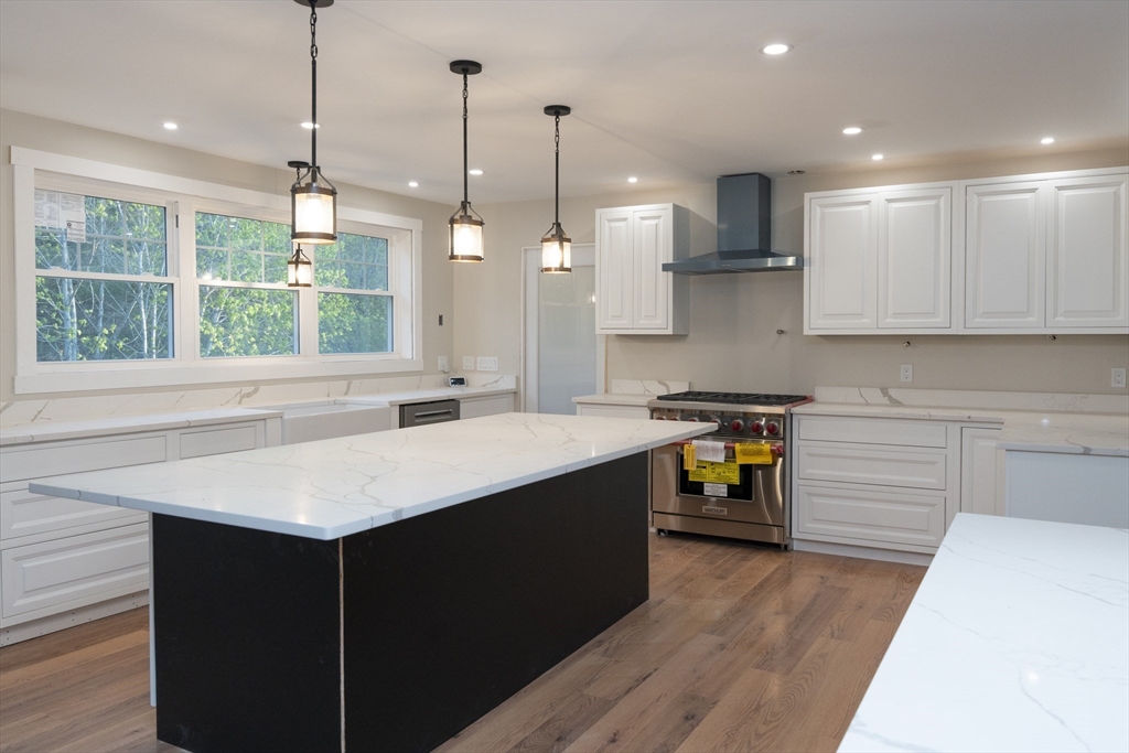 28 Marion Road Rochester, MA 02770 - Photo 2 of 23 a kitchen with a refrigerator a sink dishwasher a stove and white cabinets with wooden floor