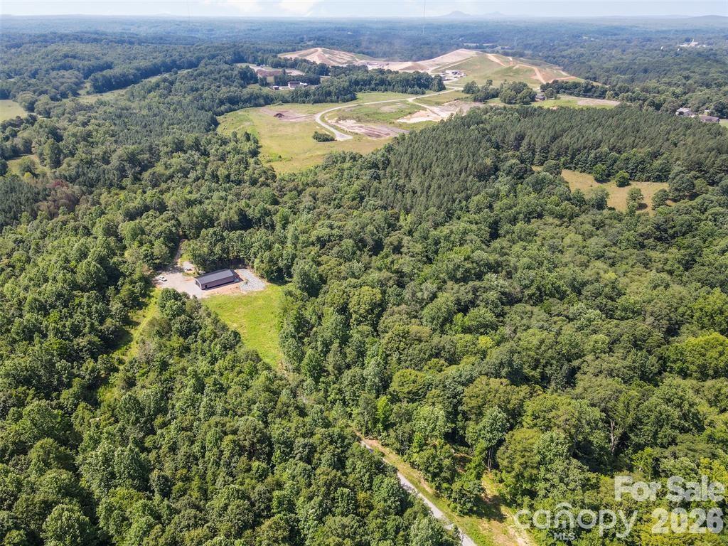 an aerial view of residential houses with outdoor space and trees