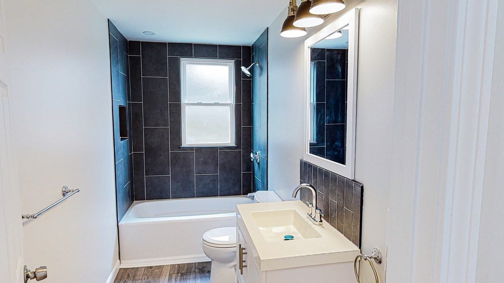 109 Deering Road, Unit 1 Boston, MA 02126 - Photo 7 of 12 a bathroom with a tub sink and mirror