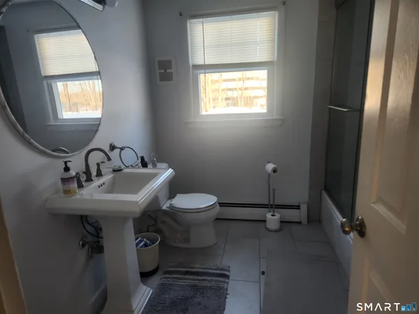 a bathroom with a toilet sink and mirror