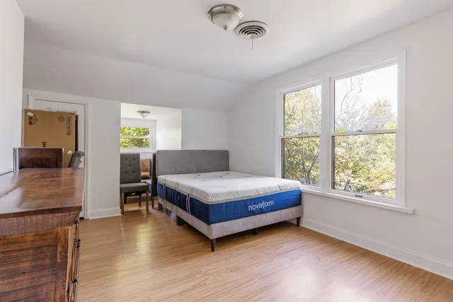 a living room with a bed furniture and a large window