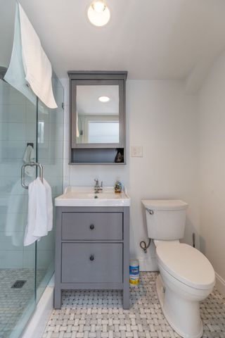 a bathroom with a toilet sink vanity and mirror