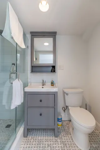 a bathroom with a toilet sink vanity and mirror