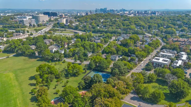 an aerial view of residential houses with outdoor space and trees