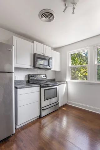 a kitchen with granite countertop a stove a sink and a refrigerator