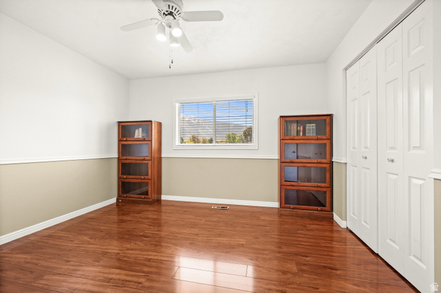 1650 Nichole Circle Sandy, UT 84093 - Photo 16 of 31 Room featuring wood-finish flooring, white bifold closet doors, a ceiling fan with integrated lighting, and a window with blinds