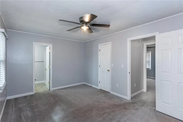 a view of an empty room and chandelier fan