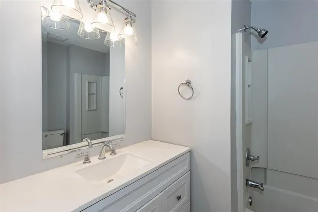 a bathroom with a sink vanity and shower