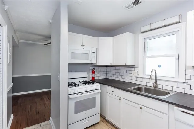 a kitchen with white cabinets sink and white appliances