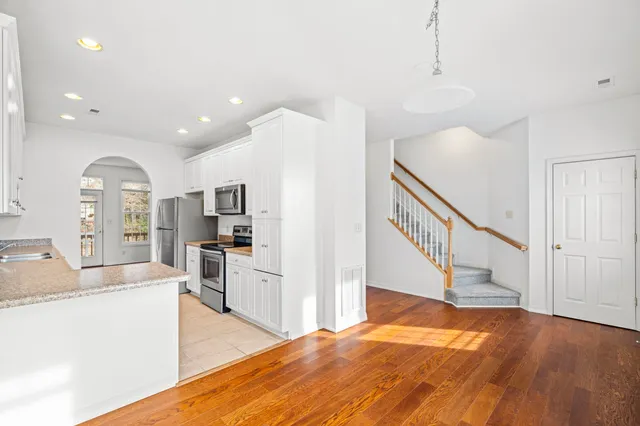 a view of a kitchen with sink and wooden floor