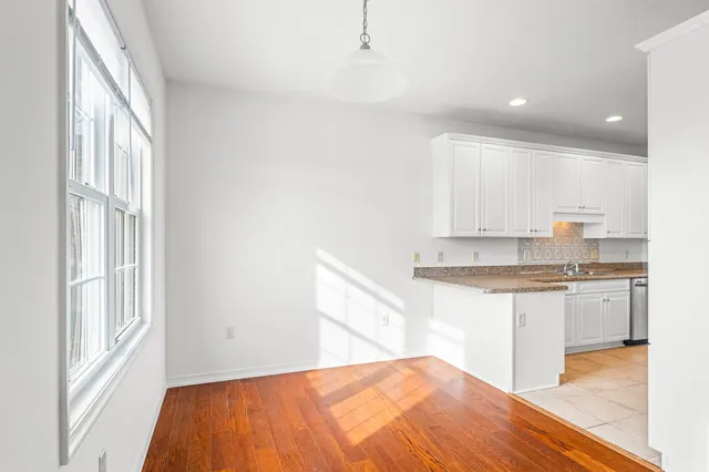 a kitchen with granite countertop white cabinets and white appliances