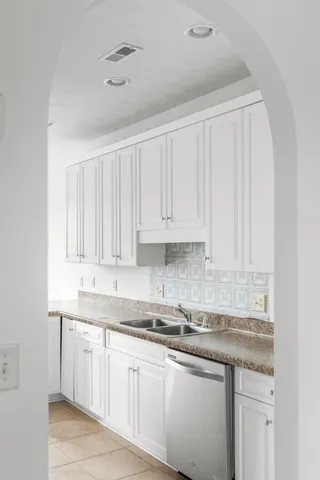 a kitchen with granite countertop white cabinets and a sink