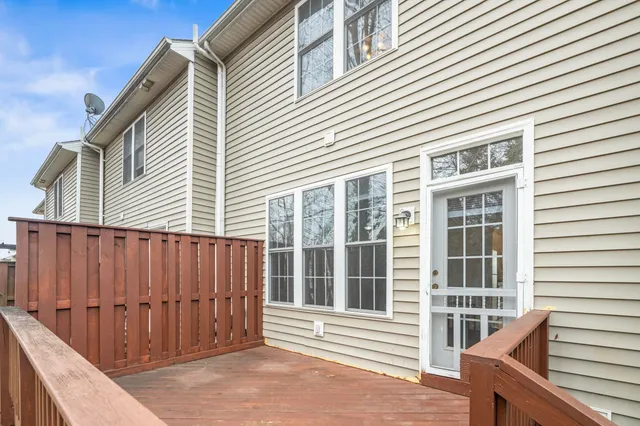 a view of a house with a large window and wooden fence