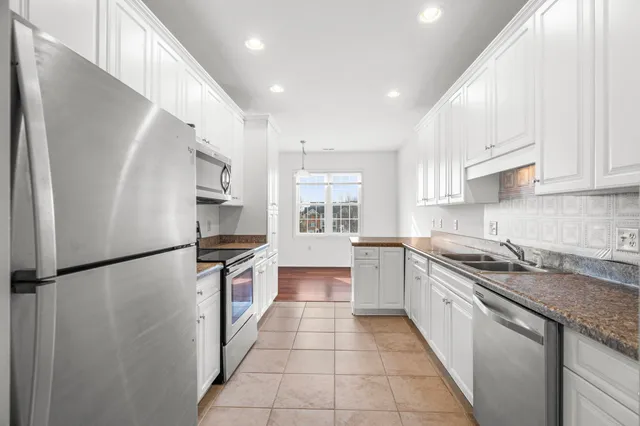 a kitchen with a sink a refrigerator and a stove