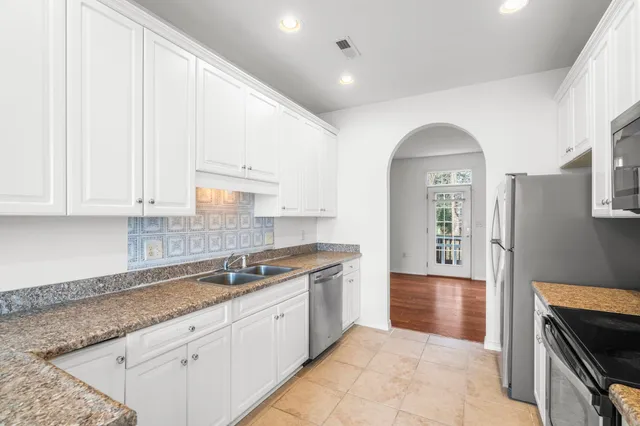 a kitchen with granite countertop white cabinets and white appliances