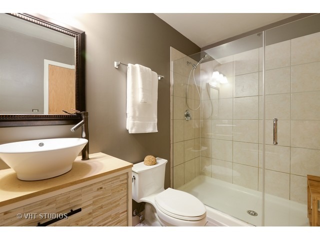 41 East 8th Street, Unit 1105 Chicago, IL 60605 - Photo 13 of 15 a bathroom with a sink a toilet a mirror and shower