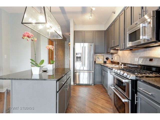 41 East 8th Street, Unit 1105 Chicago, IL 60605 - Photo 5 of 15 a kitchen with stainless steel appliances granite countertop a refrigerator a stove and a sink