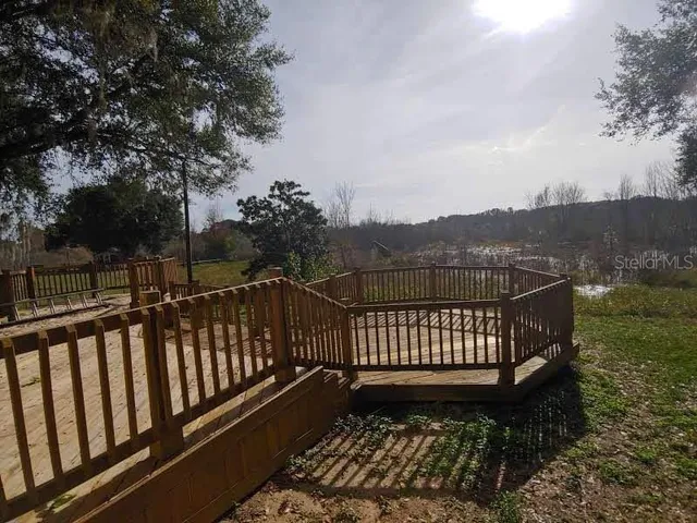 a view of a roof deck with wooden floor and fence