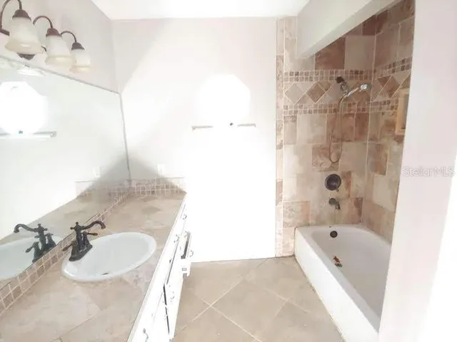 a bathroom with a tub sink and mirror