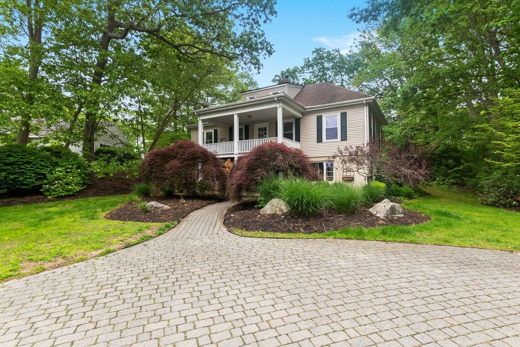 a front view of a house with a garden and yard