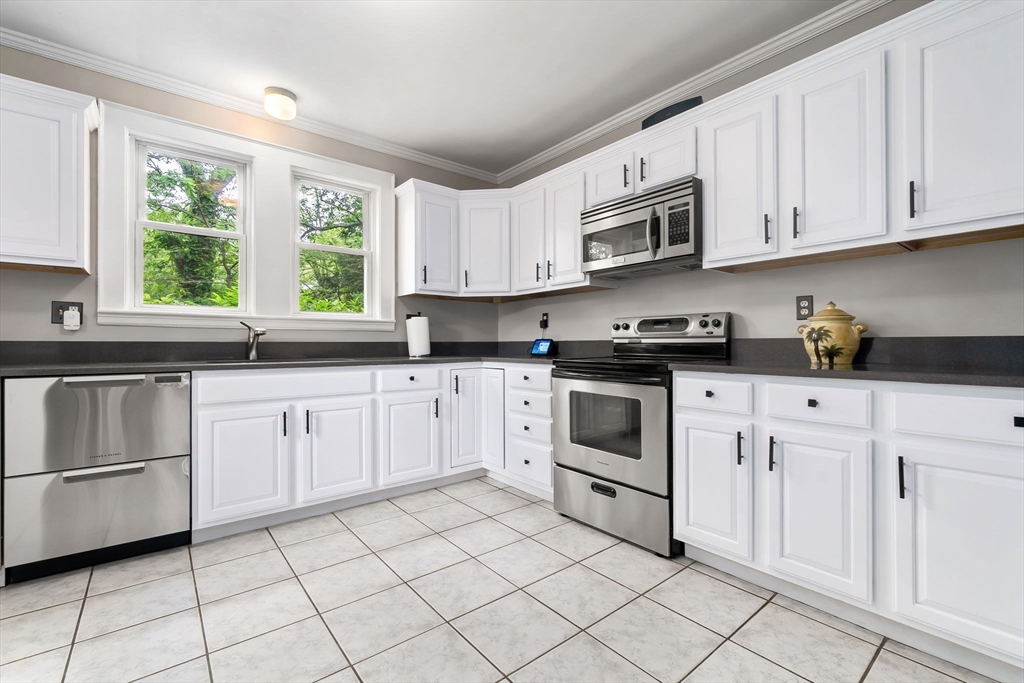 4 Valley Road Danvers, MA 01923 - Photo 9 of 42 a white kitchen with granite countertop white stainless steel appliances a sink window and cabinets