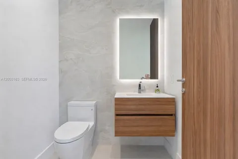 a bathroom with a toilet a sink and mirror