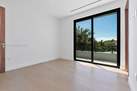 an empty room with sliding glass door and window