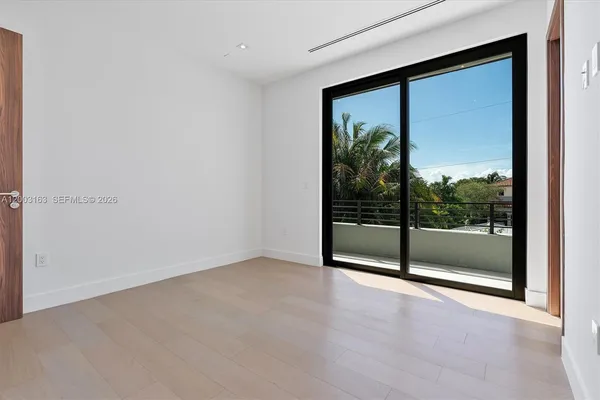 an empty room with sliding glass door and window