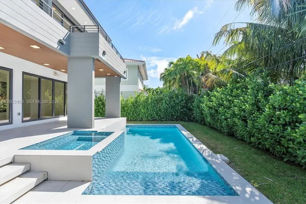 a view of a house with a small yard plants and swimming pool