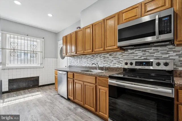 a kitchen with granite countertop a stove and a microwave