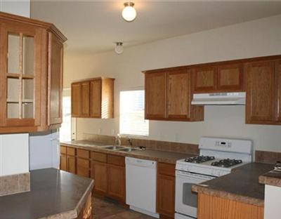 58 Alpine Ranch Road Gypsum, CO 81637 - Photo 6 of 20 a kitchen with kitchen island granite countertop a sink a stove and wooden cabinets